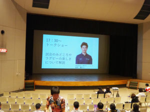 トークショーに先立ち、慶應義塾大学ラグビー部（蹴球部）が港北区内の小学校で行うラグビー教室などの紹介も映像で流されていました