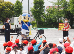 横浜Ｆ・マリノスのキャラクター「マリノスケ」と、公式チアリーティングチーム「トリコロールマーメイズ」のメンバー2人が安全な自転車の乗り方を指導した（5月12日）