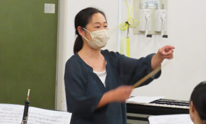 横浜在住の指揮者・西井智美さんは曲目に情熱を傾けつつも笑顔を交えて指導をおこなっているかに見えた