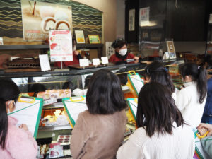 「桜餅の葉はどこから持って来て（仕入れて）いるのですか」との質問に「静岡県の伊豆から」との回答も。子どもたちは熱心にメモを取りつつインタビューを実施。お店側の気配りもあり笑顔あふれる取材となっていた