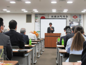 5月17日に神奈川県トラック総合会館（新横浜2）で開催された「第38回新横浜町内会総会」でも、ホームページの開設を告知していた（写真は井手口常任理事・マンション部長）