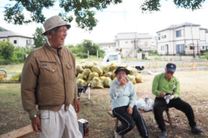 相撲連盟の事務局長を務める飯島さん（左）は太尾下町会の会長も務めるなど地域で活躍している。元会長の加藤典生（つねお）さん（右）、小森登美子さんと