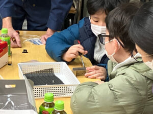 2024年度の第13回開催時、株式会社田島精研(樽町3)で行われた「工場を見学して『ピコピコスター』を完成させよう」企画の様子(港北区提供)