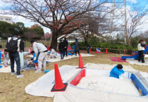 砂場や水飲み場、ベンチ2台、滑り台に、24本ある木調ポールを8本ずつ色分けして、青・白・赤の3色のペンキで塗装した