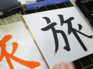 最後は記念の「色紙」に文字を書き完成へ