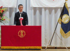 来賓として祝辞を述べた竹下港北区長。太尾小学校の3つの優れた点として、防災活動の充実（地域防災拠点としての役割）や、学校運営協議会の活動（文部科学大臣賞受賞）、音楽活動が盛んなこと（マーチングバンドの活躍）を挙げ、「また、子どもたちが地域に愛されていることを実感していることが伝わってくる」と学校の印象を語っていた