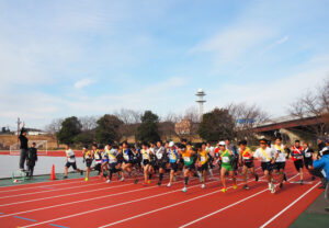 第40回記念「港北駅伝大会」第1レース（一般男子の部・高校の部）のスタート時。特別ゲストに招かれた俳優の谷原章介さんがスターターを務めた。後方は鶴見川流域センター方面（2025年1月19日、日産小机フィールド）