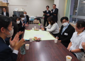 この日は9人の横浜市議が4つのグループの各テーブルに分かれて高校生との「対話」にチャレンジ。まずはそれぞれ自己紹介と、緊張感を解(ほぐ)す「アイスブレイク」で好きな食べ物を紹介しつないでいく時間が持たれました。横浜平沼高校の卒業生で元市会議長の清水富雄市議(中央左)も後輩の生徒たちを見守っていました