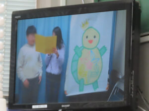 「等身大サイズ」に描かれた記念マスコット「かめさく」を披露