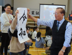 2019年5月の「新元号」への改元を前に、当時、内閣官房長官を務めていた菅義偉（すがよしひで）さん（元内閣総理大臣、前衆議院議員）が同年4月1日に掲げた「令和」を揮毫したことで知られる茂住菁邨（もずみせいそん）さんが来校した