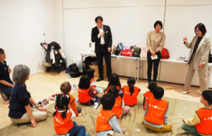 「きらぼし銀行」新綱島支店の佐藤支店長、HR部の松尾さん、境野有美子さん（左より）が子どもたちにあいさつを行った