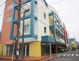 大曽根地区の最深浸水想定地点は鶴見川河川敷に位置するコヤマドライビングスクール横浜校（大曽根2）の「3.7m」。最大の被害想定で2階に届くか到達するほどの場所に「青テープ」を巻き付け注意喚起を行う